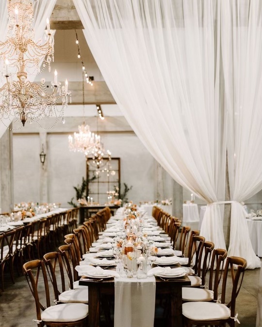 Long table with chairs set for wedding reception dinner using event rentals from Two Rivers