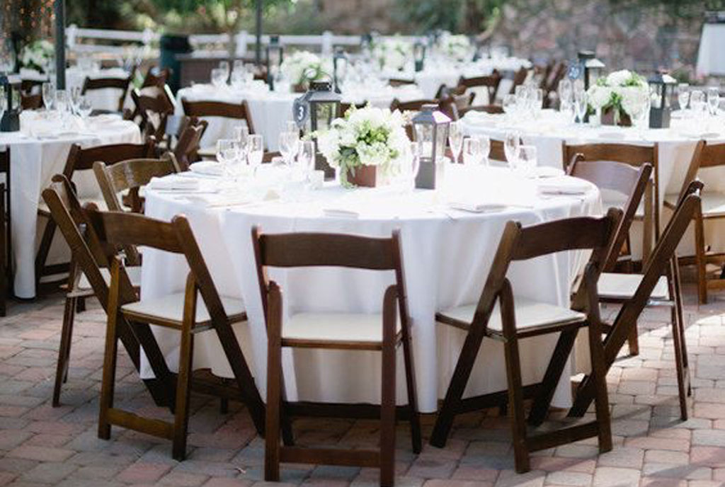 Brown folding chairs set around circular table for dinner service